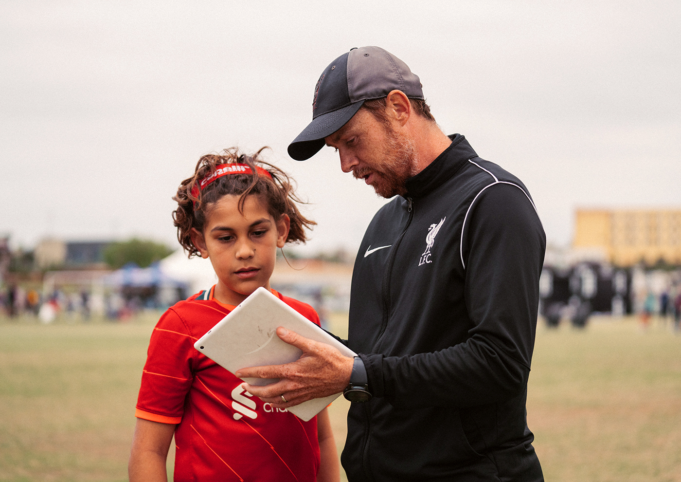 coach instructing player on soccer field