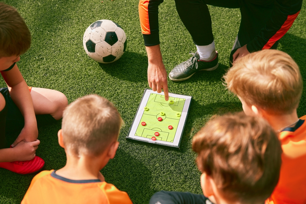 soccer coach teaching kids